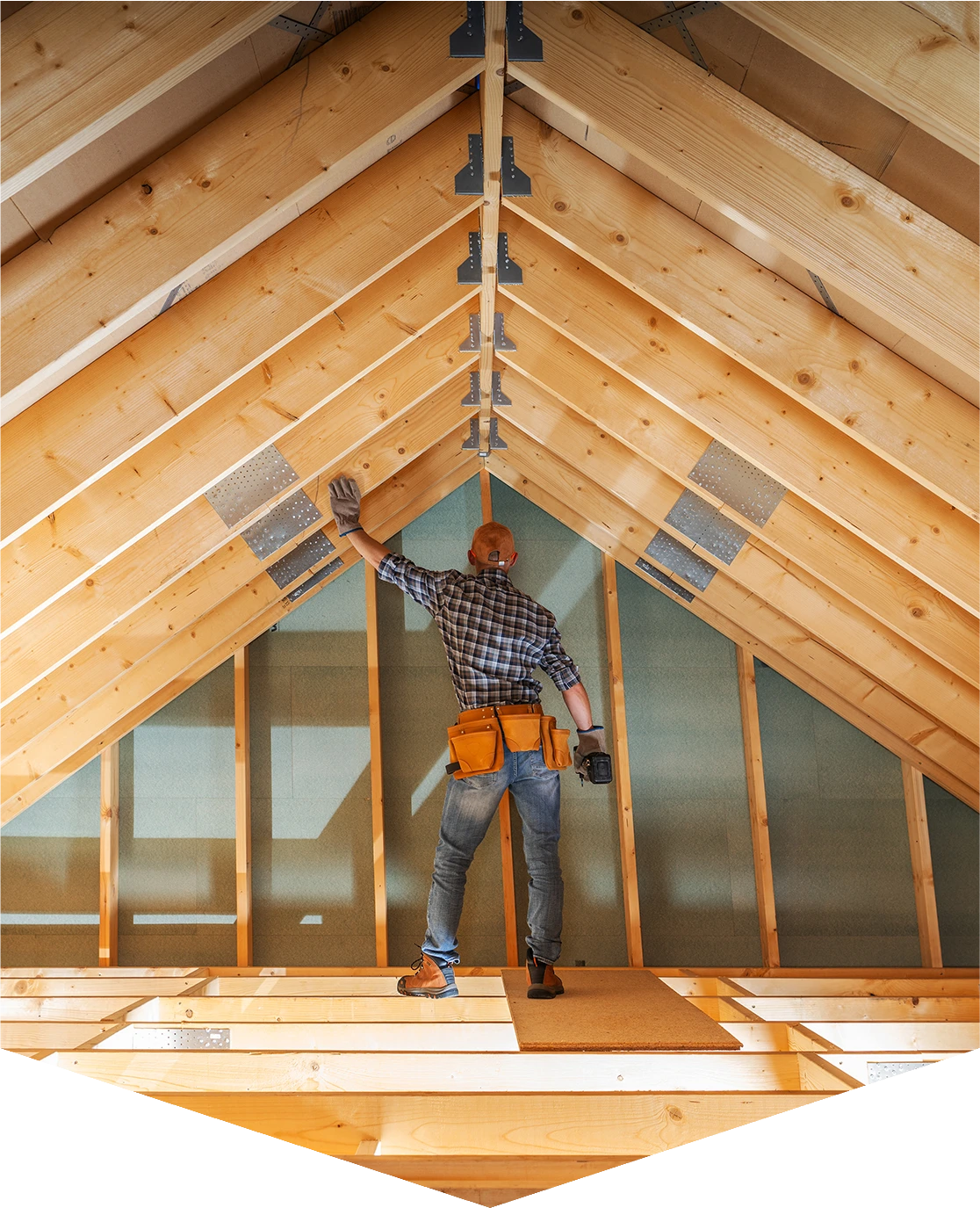 Builder inspecting wooden attic framework.