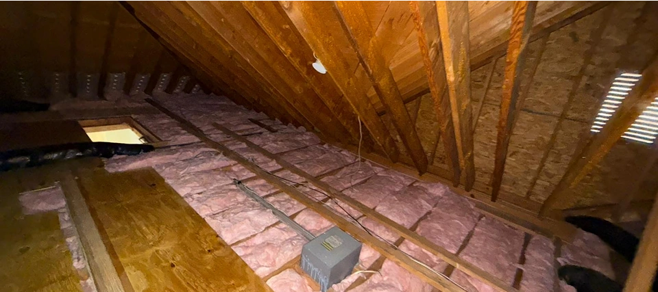 Insulated attic with wooden beams.