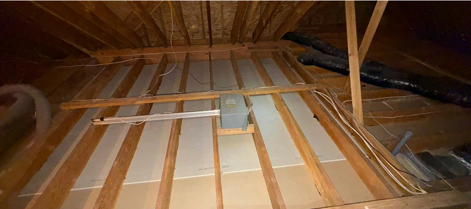 Wooden attic ceiling with exposed beams.