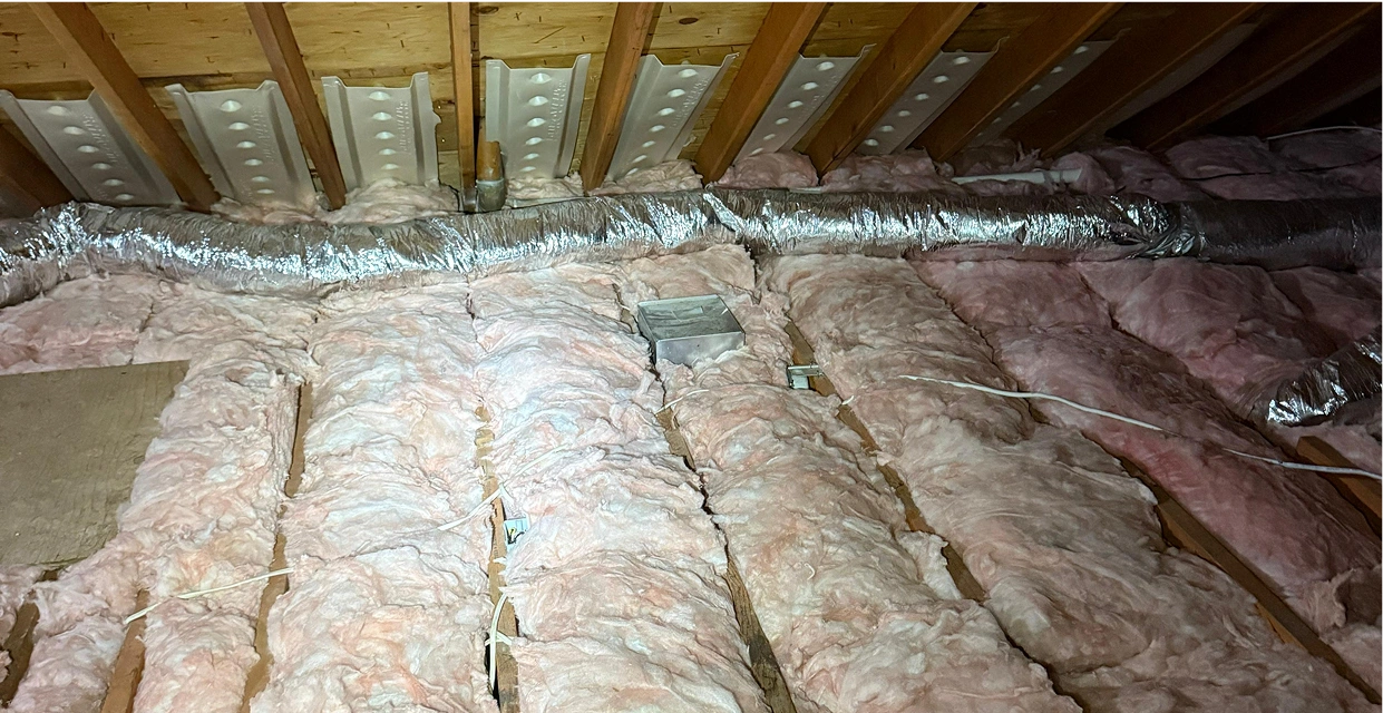 Attic insulation with exposed wooden beams.