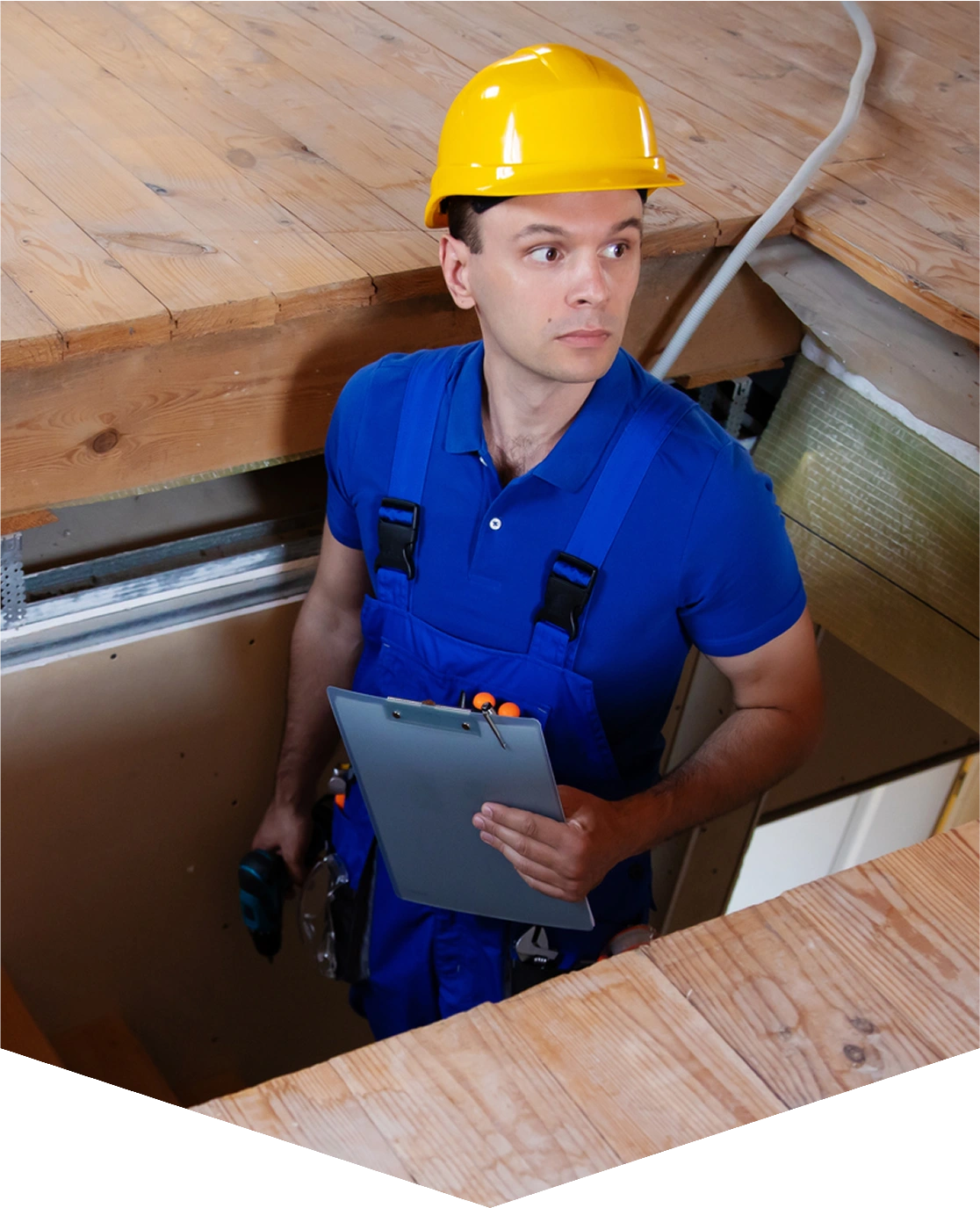 Worker inspecting attic with clipboard and tools.